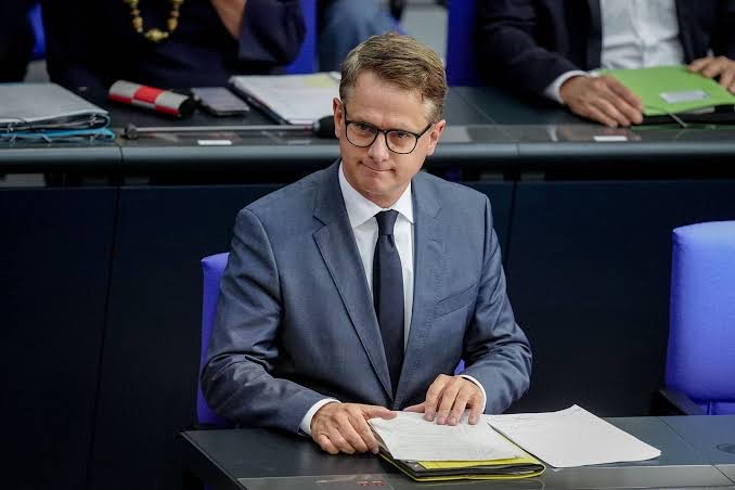 Carsten Linnemann seated on the plenary benches of the German Bundestag with papers in front of him